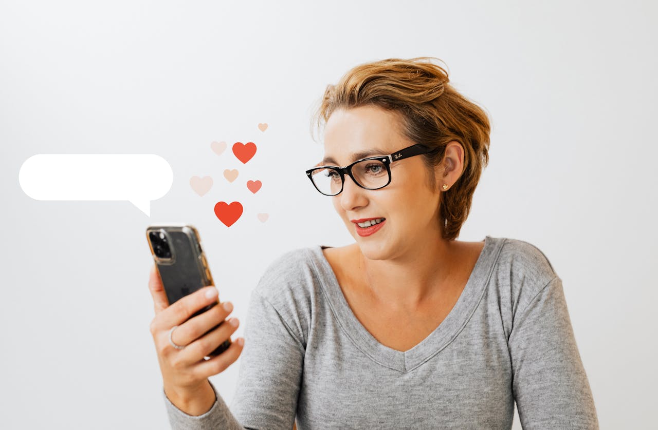Adult woman wearing eyeglasses and using phone, surrounded by digital love heart symbols on a white background.
